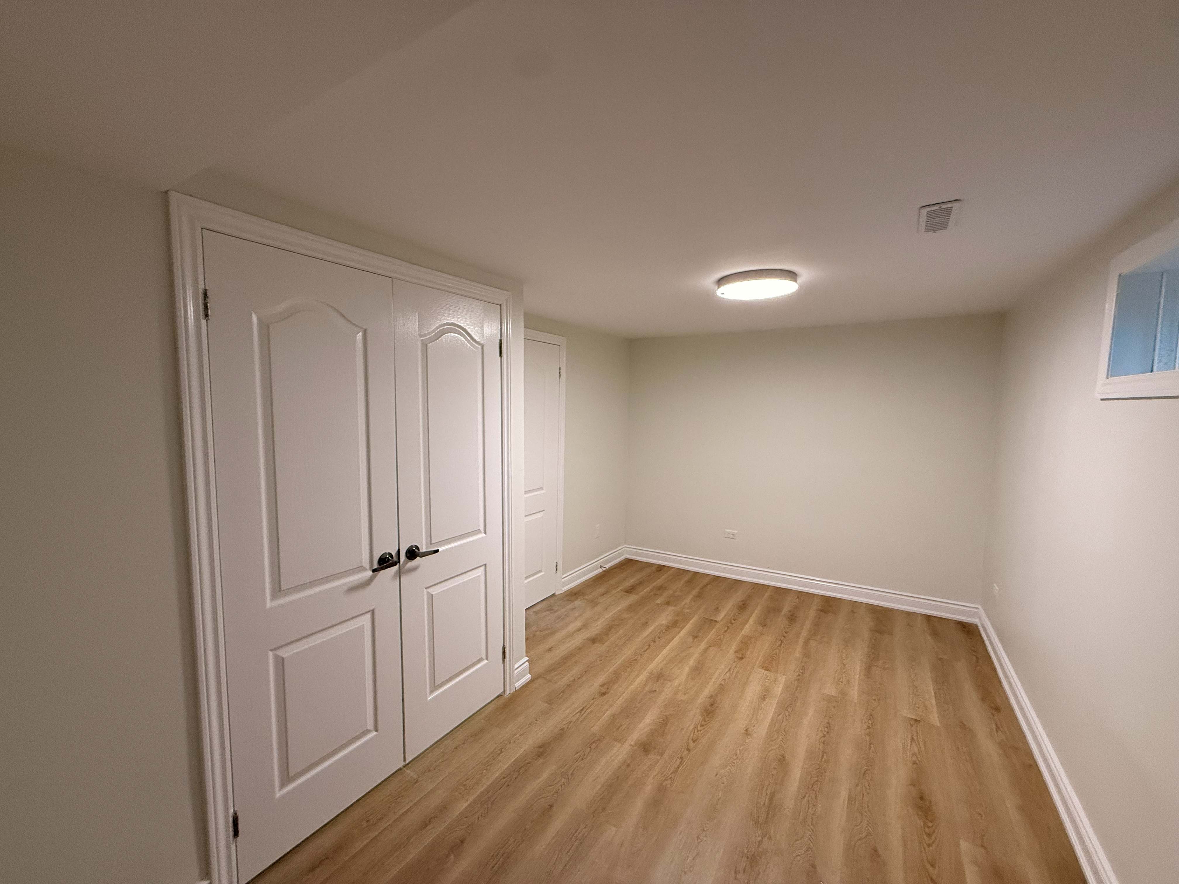 Finished open-concept living suite with hardwood flooring